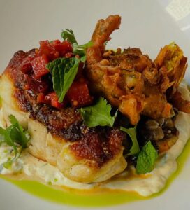 Market fresh Corvina seabass perfectly paired with tangy rhubarb chutney, crispy spring onion pakora, cooling cucumber yogurt, and fragrant herbs.