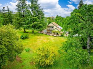 Aerial shot of a home on landlots of green