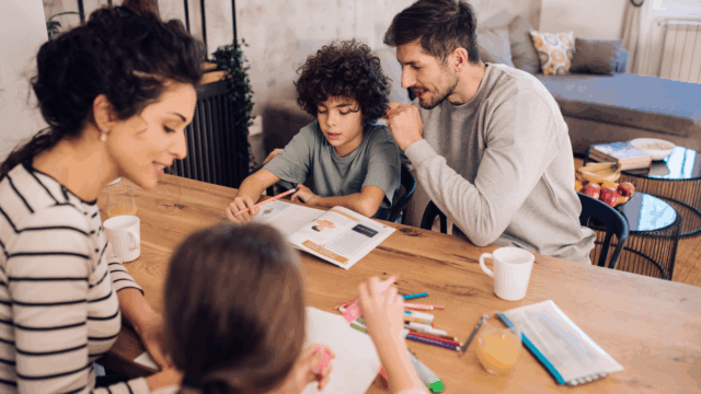 Family at table, parents hellping kids with homework 