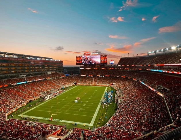Aerial photo of Levi's Stadium at dusk during a football game. 